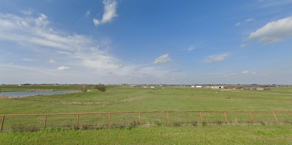 Wide pasture under a large sky, with the neighboring lake visible at left.